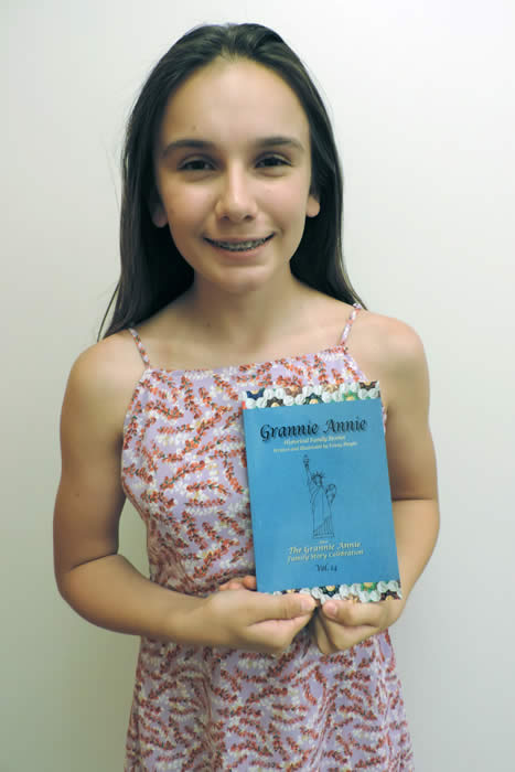 Grannie Annie published student 2019, holding a copy of "Grannie Annie, Vol. 14"
